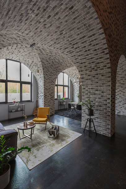 modern luxury design of a brutal apartment interior with arches in the style of a medieval castle with bright accents. free layout, kitchen area, seating and eating area. - Zdjęcie, obraz
