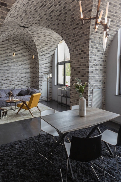 modern luxury design of a brutal apartment interior with arches in the style of a medieval castle with bright accents. free layout, kitchen area, seating and eating area. - Фото, зображення