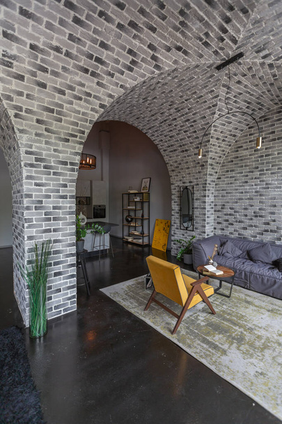 modern luxury design of a brutal apartment interior with arches in the style of a medieval castle with bright accents. free layout, kitchen area, seating and eating area. - Fotografie, Obrázek