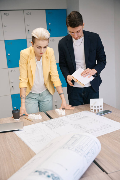 Team of construction engineers working at house development project, drawing blueprint and making paper layout, creative brainstorm - Foto, imagen