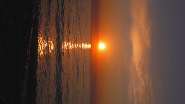 Ο ρομαντισμός και το μυστήριο του ηλιοβασιλέματος φέρνουν μαγεία στο απογευματινό τοπίο. Λάμψη και μεγαλείο της φύσης, αντανακλάται στην επιφάνεια του νερού, δημιουργούν μοναδικές και αμίμητες εικόνες. κατακόρυφο βίντεο - Πλάνα, βίντεο