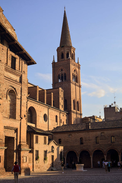 Plaza empedrada y lado de la iglesia de San Andrea con su campanario al atardecer - Foto, Imagen