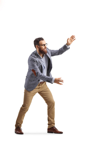 Full length shot of a cheerful bearded man trying to catch something isolated on white background - Foto, Imagen