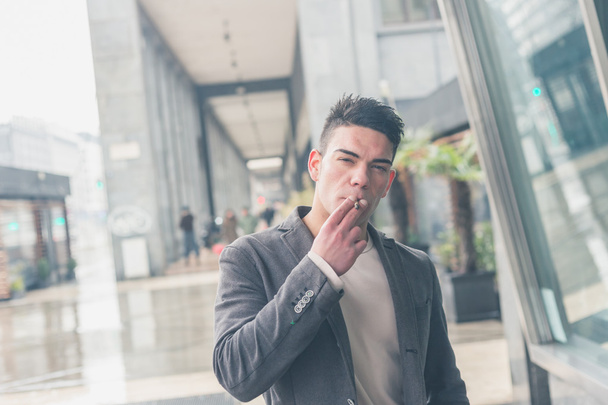 Young handsome man smoking a cigarette - Foto, Bild