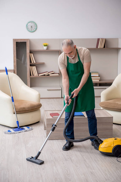 Régi vállalkozó takarítja a házat. - Fotó, kép