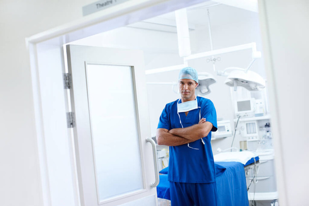 Confident in his walkspace. A handsome male doctor standing in the doorway of his operating theatre - Foto, Bild