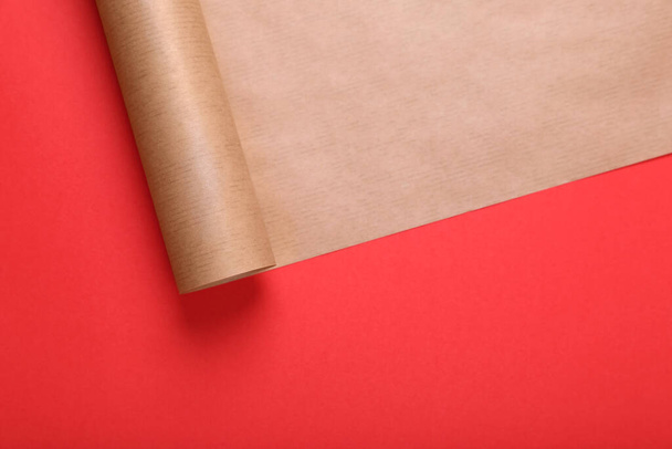 Roll of wrapping paper on red background, top view. Space for text - Zdjęcie, obraz