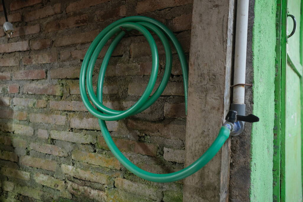 Foto eines grünen Wasserschlauchs auf einer Rolle - Foto, Bild