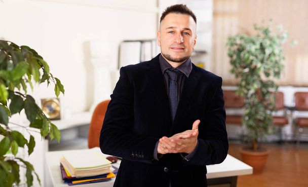 Caucasian businessman in suit standing in his office and looking in camera. - Foto, immagini