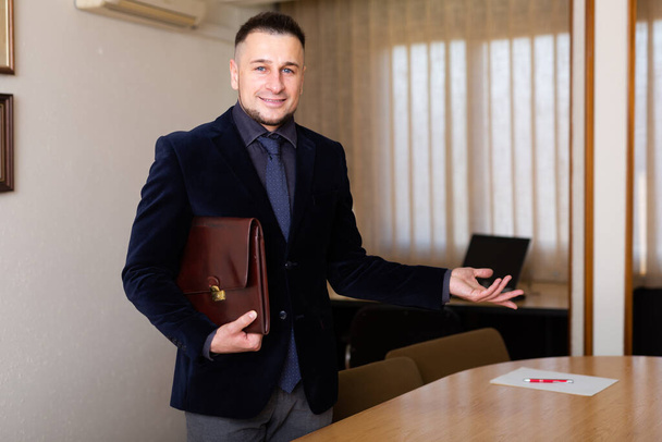 Portrait of positive young businessman meeting visitors at company office - Fotoğraf, Görsel