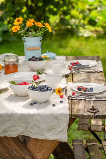 Deliciosos y dulces panqueques americanos para desayunar en un soleado jardín. Desayuno en el jardín de primavera. - Foto, imagen