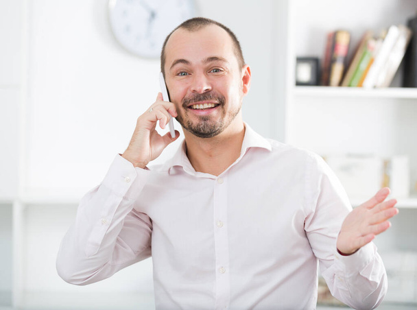 Young happy european businessman in office talking by smartphone - Foto, Imagem