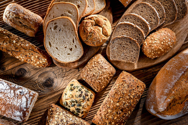 Assorted bakery products including loaves of bread and rolls - Foto, imagen