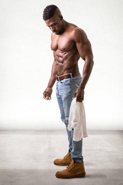 African American bodybuilder man, naked muscular torso, wearing jeans, looking down - Φωτογραφία, εικόνα