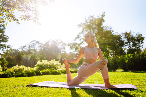 Young beautiful woman practices yoga and meditation at the public park. Sport, Active life. Fitness. - Fotografie, Obrázek