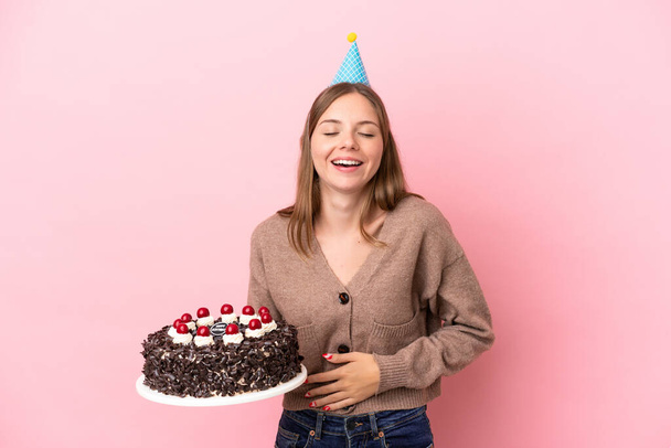 若いですリトアニア人女性保持誕生日ケーキ隔離上のピンクの背景笑顔多く - 写真・画像