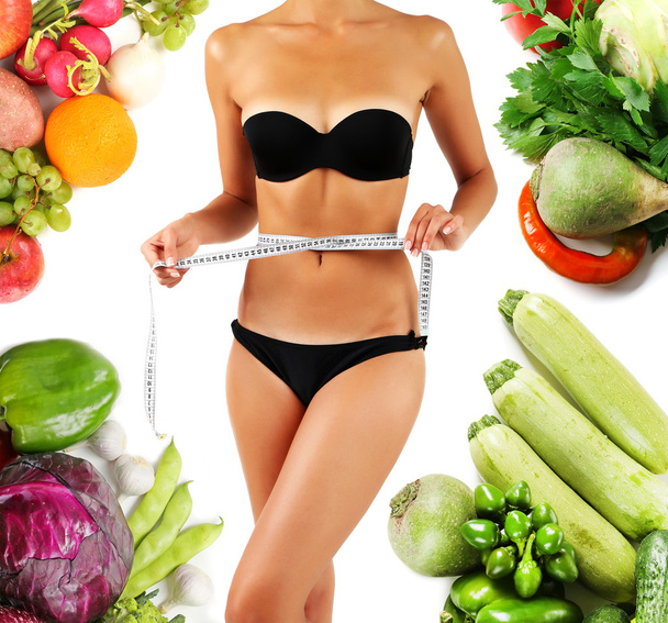 Beautiful young woman measuring her body with tape isolated on white and vegetables around - Foto, imagen