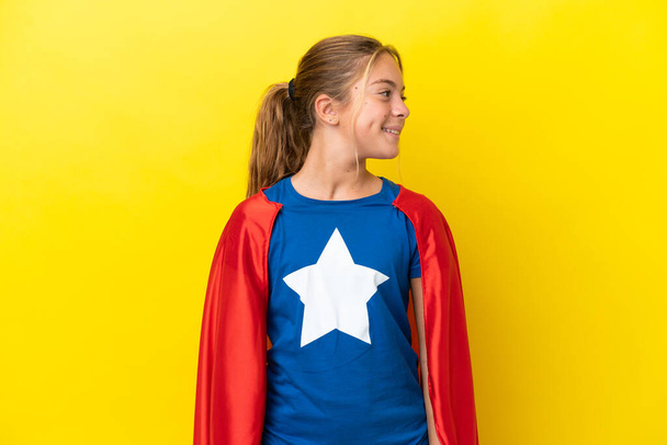 Super Hero kislány elszigetelt sárga háttér látszó oldalán - Fotó, kép