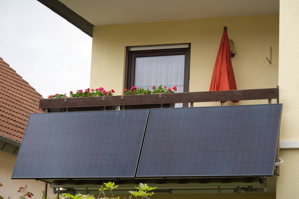 Planta de energía solar en una barandilla de balcón con cajas de flores arriba - Foto, imagen