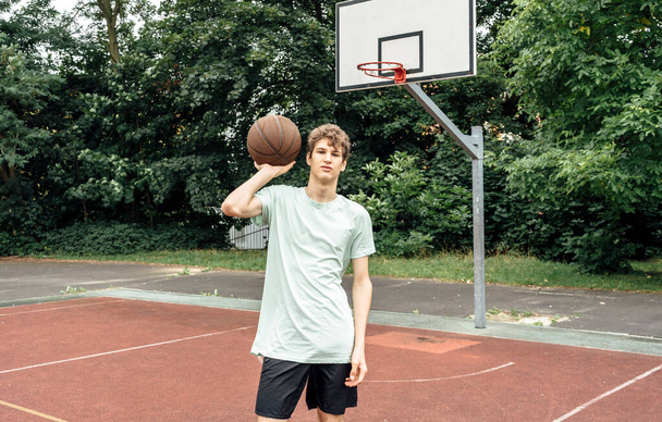 Niño jugando baloncesto en la cancha. Adolescente corriendo en el estadio. Deportes, hobby, estilo de vida activo para los niños - Foto, Imagen