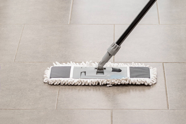 Cleaning gear mopping a living room floor with tile - Foto, afbeelding