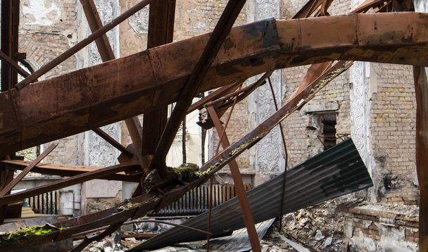 Bombardovaná budova kulturního domu ve městě. Válka Ruska proti Ukrajině. Zničené podlahové trámy uvnitř budovy, které zasáhla dělostřelecká nábojnice, raketa nebo vzdušná bomba - Fotografie, Obrázek