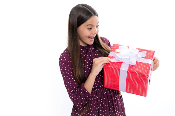 Emotional teenager child hold gift on birthday. Funny kid girl holding gift boxes celebrating happy New Year or Christmas. Portrait of emotional amazed excited teen girl - Photo, image