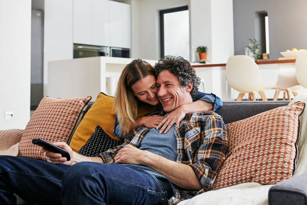 Happy, couple and hug for watching tv in home, cable movies and news show of film media in lounge. Mature man, woman and love with television remote, subscription and connection to streaming platform. - Foto, Imagem
