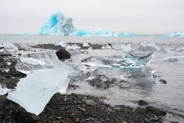 Kék jéghegyek az óceáni vízben. Gleccser Jég sodródás a Nyugodt Víznél. Tiszta jégdarabok az olvadó gleccserből. Jeges téli táj. Foggy Időjárás Izland.. Kiváló minőségű fotó - Fotó, kép