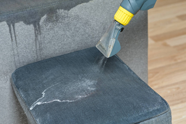 Sofa chemical cleaning with professionally extraction method. Wet textile sofa cleaning. home cleaning service. cleaning sofa with washing suction cleaner closeup. - Photo, Image