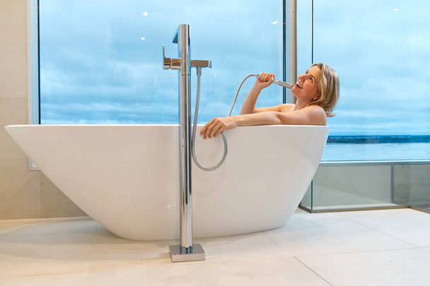 Nainen vapaassa valkoisessa kylvyssä. Moderni kylpyhuoneen sisustus. Kauneus, terveelliset elämäntavat. panoraama kylpyhuone sisustus - Valokuva, kuva