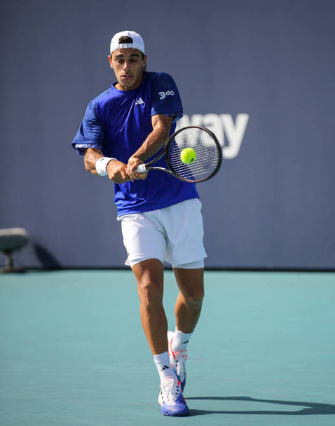 MIAMI GARDENS, FLORIDA - MARCH 27, 2023: Francisco Cerundolo of Argentina in action during round of 32 match against Felix Auger Aliassime of Canada at 2023 Miami Open at the Hard Rock Stadium in Miami Gardens, Florida, United States - Photo, Image