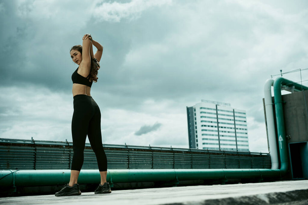 Jovem mulher streching músculos antes de exercícios ao ar livre. - Foto, Imagem