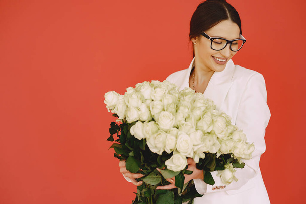 Beautiful girl in a studio. Stylish girl on a brown background. Lady with bouquet of white roses. - Foto, immagini