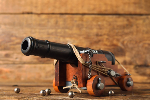木製の背景に大砲のおもちゃモデル - 写真・画像