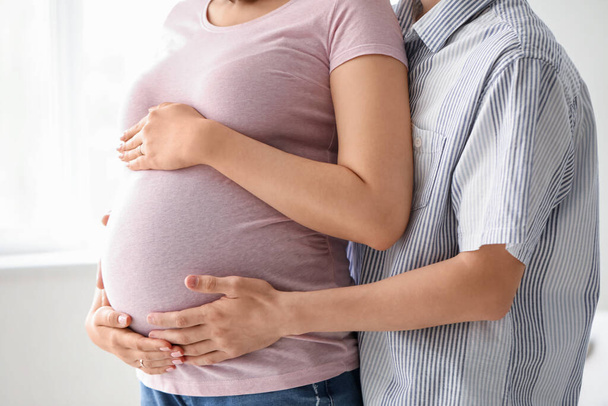 jong zwanger paar knuffelen thuis, close-up - Foto, afbeelding