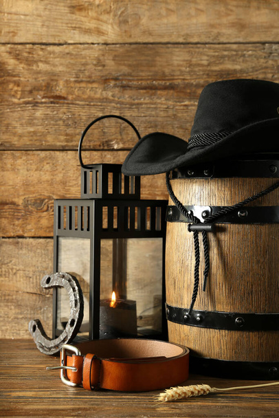 Композиция с ковбойской шляпой, поясом и подковою на деревянном фоне - Фото, изображение