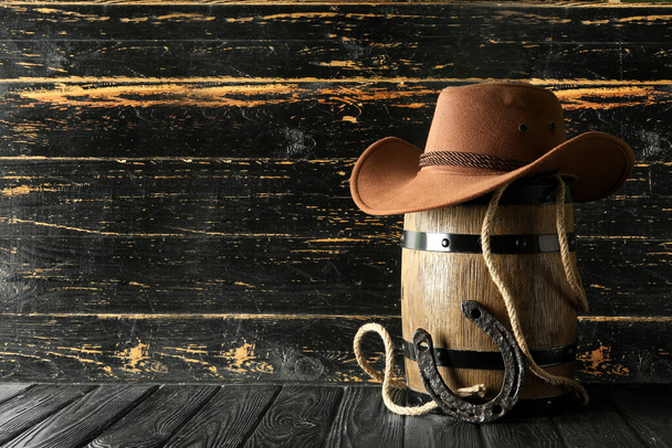 cowboyhoed, lasso en hoefijzer op houten ondergrond - Foto, afbeelding