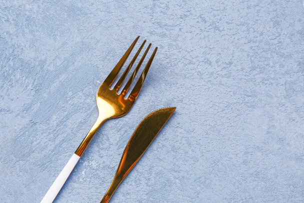 Fourchette et couteau en acier inoxydable sur fond bleu grunge - Photo, image