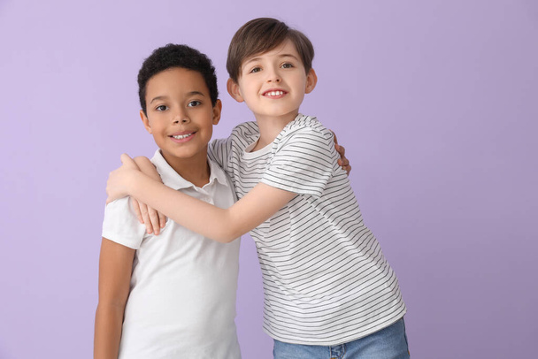 Милые маленькие мальчики обнимаются на фоне сирени - Фото, изображение
