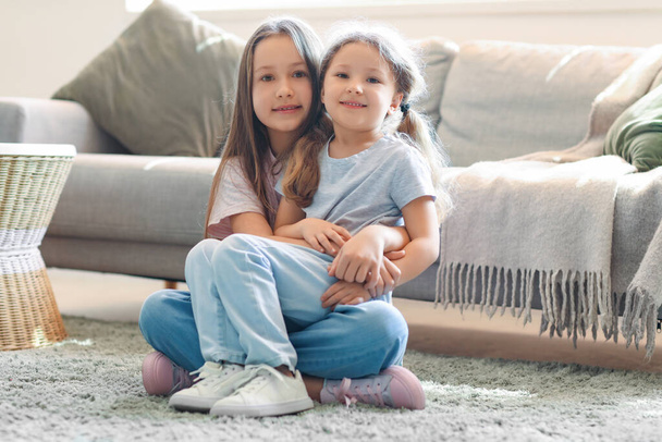 Cute little sisters hugging at home - Valokuva, kuva