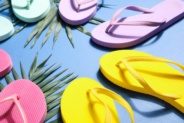 Colorful flip flops with palm leaves on blue background - Photo, Image