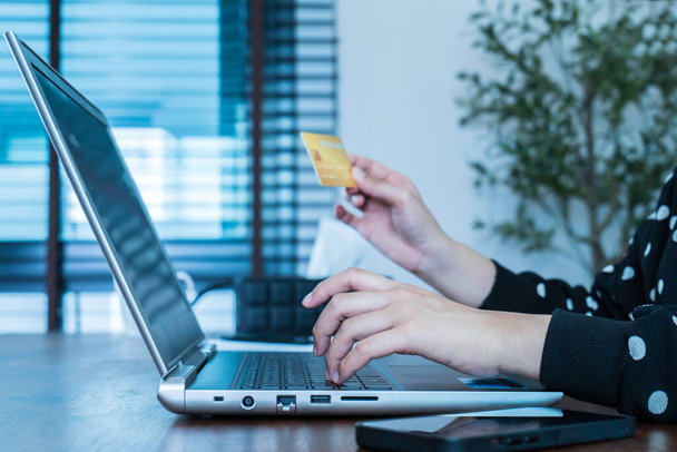Young woman using laptop computer and holding credit card to shopping online, e-commerce and internet banking working from home. The payment method contactless money. Online shopping concept. - Φωτογραφία, εικόνα