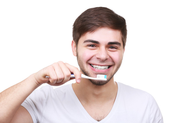 Portrait of young man with toothbrush in hand isolated on white - Fotografie, Obrázek