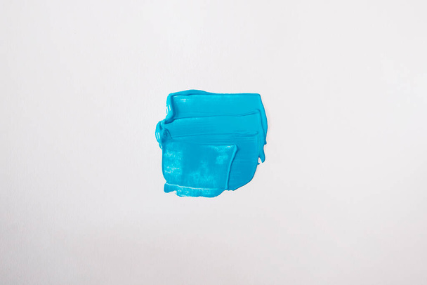 Blue smear on a white background. Top view, flat lay. - Foto, Bild