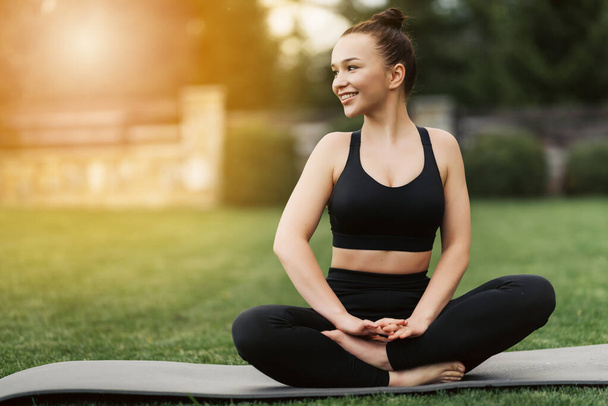 Portret szczęśliwej młodej kobiety ćwiczącej jogę na świeżym powietrzu.Koncepcja jogi i relaksu. - Zdjęcie, obraz