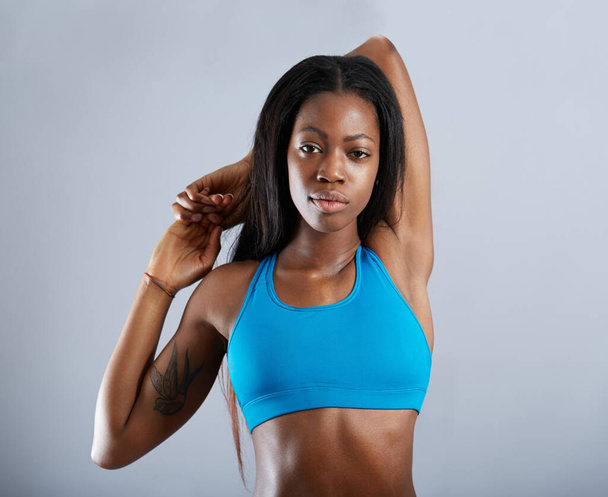 Black woman, studio portrait and stretching arms for fitness, exercise or muscle health by background. Girl, model and workout fashion with warm up, start and training for body wellness by backdrop. - Foto, Bild