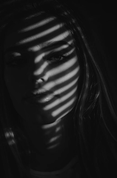 Beautiful girl in shadow. Sensual fashion woman face close up. Beauty portrait of young sexy woman - Foto, afbeelding