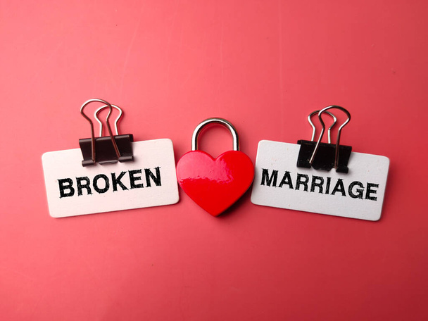 Lucchetto amore con la parola BROKEN MARRIAGE su sfondo rosso - Foto, immagini