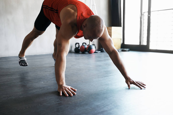 Workout, gym and man doing floor exercise, health commitment and athletic training for muscle building growth. Fitness club, healthy body or strong person, bodybuilder or athlete doing floor push up. - Photo, image